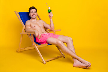 Poster - Portrait of attractive cheerful guy drinking mojito in plage isolated over bright yellow color background