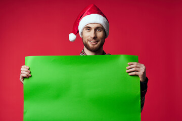 Wall Mural - Cheerful man in a santa hat holding a banner holiday isolated background