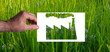 Green wash: A man's hand holds a blank sheet of paper with the silhouette of a factory cut out. Green grass background.
Not everything 