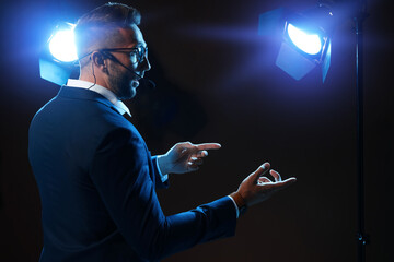Motivational speaker with headset performing on stage. Space for text