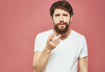 Wall Mural - emotional man in a white t-shirt irritated facial expression Studio