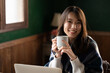 © kapinon - コーヒーを飲みながらくつろぐアジア人（日本人）女性　カメラ目線　コピースペースあり