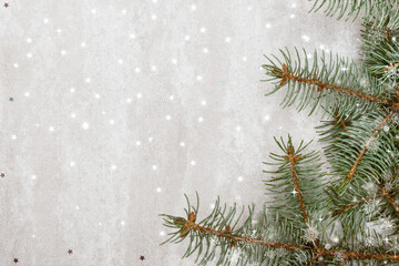 gray background with a sprig of fir, snowflakes and silver stars. Christmas or New Year card. Place for text