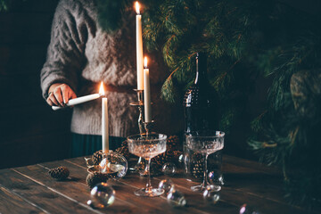 Woman lighting candles for Christmas diner.