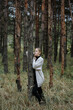© Andrii - girl in a gray cape and black dress among the autumn forest