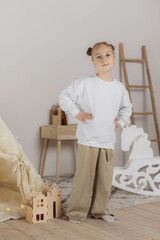 Minimalist studio photos with scandinavian decor of young girl wearing in beige pants and basic clear white sweatshirt for creating mockup design and presentation print design