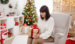 © Di Studio - Happy woman open present in christmas room