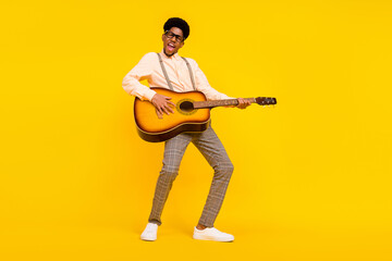 Wall Mural - Photo of carefree entertainer guy hold guitar play composition wear suspenders shirt isolated yellow color background