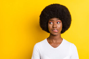 Sticker - Photo of unhappy troubled young dark skin woman look empty space bite lip isolated on yellow color background