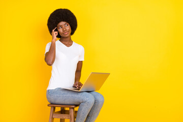 Sticker - Photo of charming thoughtful dark skin lady wear t-shirt sitting chair typing device looking empty space isolated yellow color background