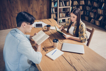 Poster - Portrait of two attractive creative focused people doing task reading science book at library loft industrial interior indoors