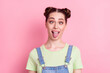 Photo of funky foolish girl grimace crossed eyes protrude tongue wear jeans overall green t-shirt isolated on pink background