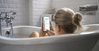 © Gorodenkoff - Beautiful Blonde Girl Takes a Bath Uses Smartphone For Checking Social Network while Relaxing. Attractive Girl Uses Mobile Phone for Browsing Social Media, Chatting with Friends, Surfing Internet.