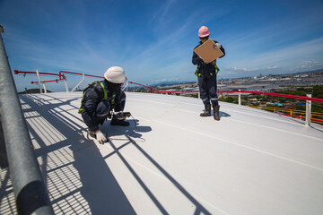 Wall Mural - Male two worker are for inspection ultrasonic thickness roof plate top