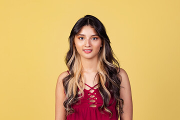 Wall Mural - Close-up portrait of young beuatiful girl, student in bright red top isolated on yellow studio backgroud.