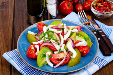 Wall Mural - Healthy vegetable salad with tomatoes and squid pieces. Studio Photo.