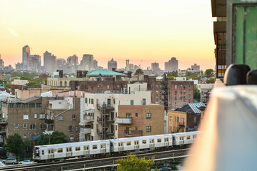 Train leaving station in Brooklyn NYC during sunset.