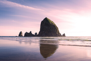 haystack rock in cannon beach reflecting in the waves 