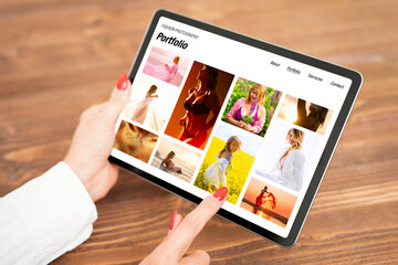 Wall Mural - Woman looking at fashion photography portfolio on tablet computer