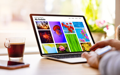 Wall Mural - Person viewing nature photographer photo portfolio website on laptop computer