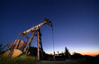 © anatoliy_gleb - Beautiful panoramic view of night oil filed with petroleum pump jack. Oil pump rocker-machine with violet blue sky at sunrise on background. Concept of petroleum industry and oil extraction.