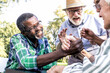 © oneinchpunch - Group of senior friends playing arm wrestling at the park