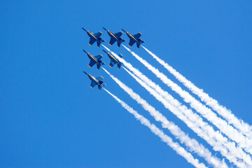 Group of flying aircrafts against a blue sky during an airshow