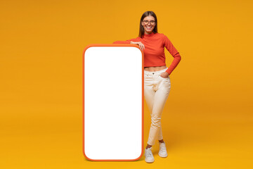 happy young woman standing and showing blank screen of huge phone, mockup for your app