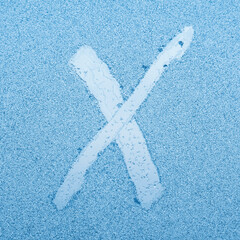 Wall Mural - The letter X written on glass with frost in the frost in winter, close up