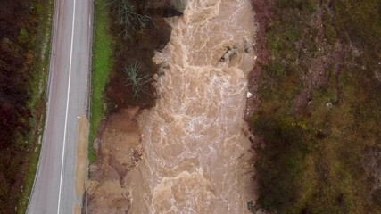Powerful river. Water flood on river after heavy rain. Swollen river in autumn. Muddy and dirty water flows. Raging river in nature.