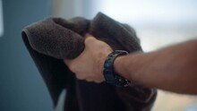 Shirtless caucasian man dries his hands hands in slow motion after washing them while wearing a sport watch and wedding ring.