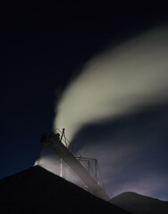 Wall Mural - Working stone crushing equipment at a mining enterprise at night, long exposure. Quarry mining machinery.