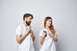 © SHOTPRIME STUDIO - married couple in white T-shirts with phones in their hands studio lifestyle