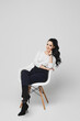 A young woman in white blouse and dark pants isolated at white background. Female office worker on white background. Official style fashion concept
