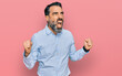 © Krakenimages.com - Middle aged man with beard wearing business shirt crazy and mad shouting and yelling with aggressive expression and arms raised. frustration concept.
