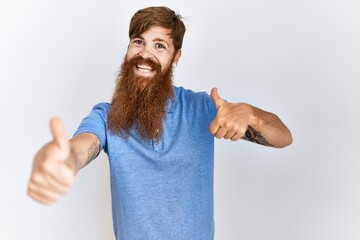 Poster - Caucasian man with long bear standing over isolated background approving doing positive gesture with hand, thumbs up smiling and happy for success. winner gesture.