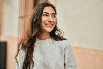 Wall Mural - Young middle east girl smiling happy standing at the city.