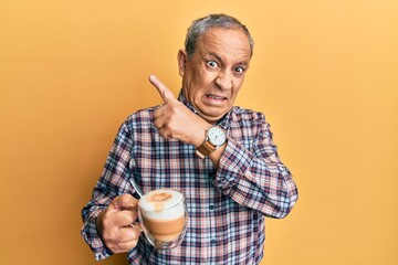 Sticker - Handsome senior man with grey hair drinking a cup coffee pointing aside worried and nervous with forefinger, concerned and surprised expression