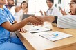 © Krakenimages.com - Group of doctor smiling and clapping to partners handshake in a medical meeting at the clinic office.
