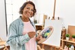 © Krakenimages.com - Middle age hispanic artist woman smiling happy drawing at art studio.