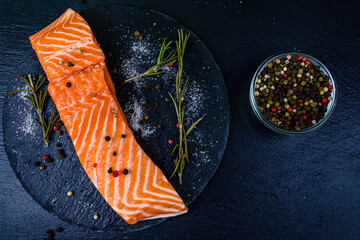 Wall Mural - Raw fillet of salmon fish and spices on a slate board. Top view