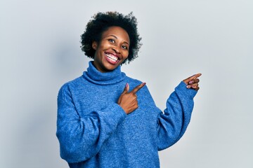 Wall Mural - Young african american woman wearing casual clothes smiling and looking at the camera pointing with two hands and fingers to the side.