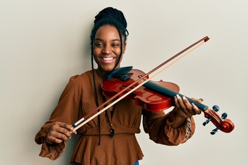 Poster - African american woman with braided hair playing violin winking looking at the camera with sexy expression, cheerful and happy face.