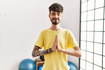 Sticker - Young hispanic man smiling confident training yoga at center.