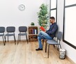 © Krakenimages.com - Young hispanic man reading book sitting on chair at waiting room