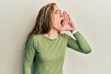 Young Blonde Woman Wearing Casual Clothes Shouting And Screaming Loud To Side With Hand On Mouth. Communication Concept.