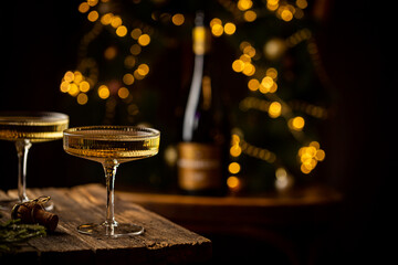 Two Glasses of champagne and bottle against fireworks and holiday lights, dark background