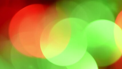 Wall Mural - Smooth motion Christmas bokeh. Large round illuminated bokeh of green and red colors slowly move, sparkle and mix like light leaks. Can be used as a New Year festive background or overlay.