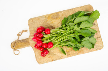 Canvas Print - Bunch of fresh radishes on kitchen wooden cutting board. Studio Photo