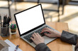 © amnaj - Close-up of a businesswoman working on a laptop blank white screen at office. Mock up.